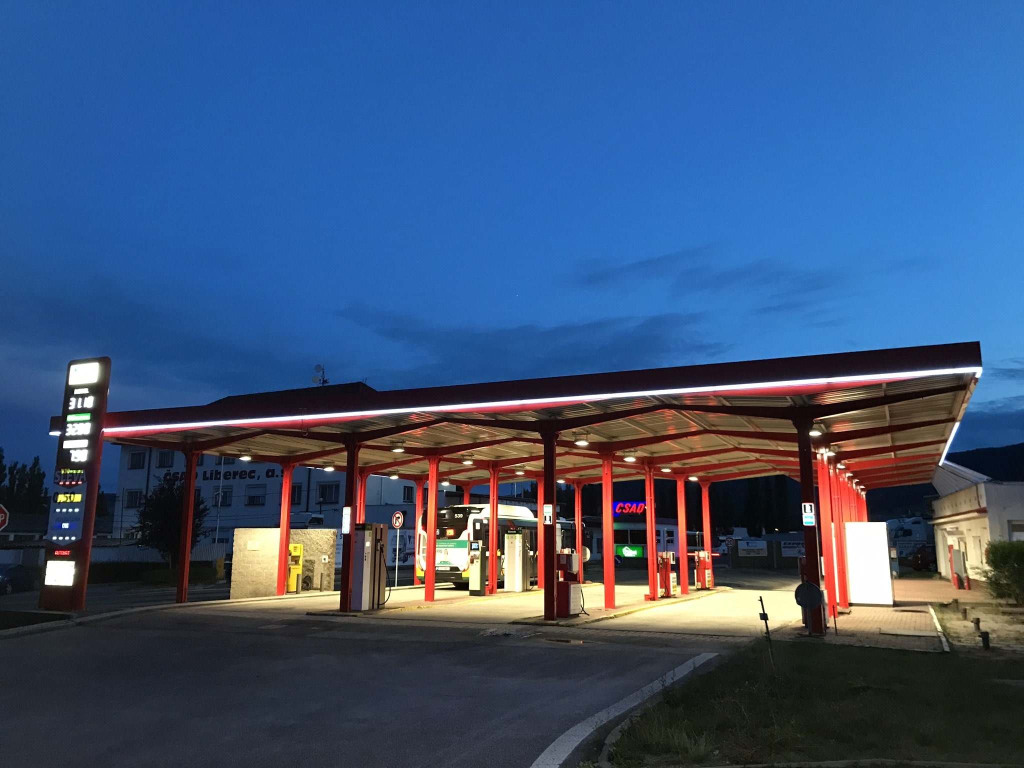 Celkový pohled na čerpací stanici LIAD za soumraku – zastřešení, výdejní stojany a cenový totem